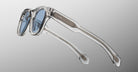 Jacques Marie Mage Kinshasa sunglasses, clear frames, blue lenses, shown at an angle.