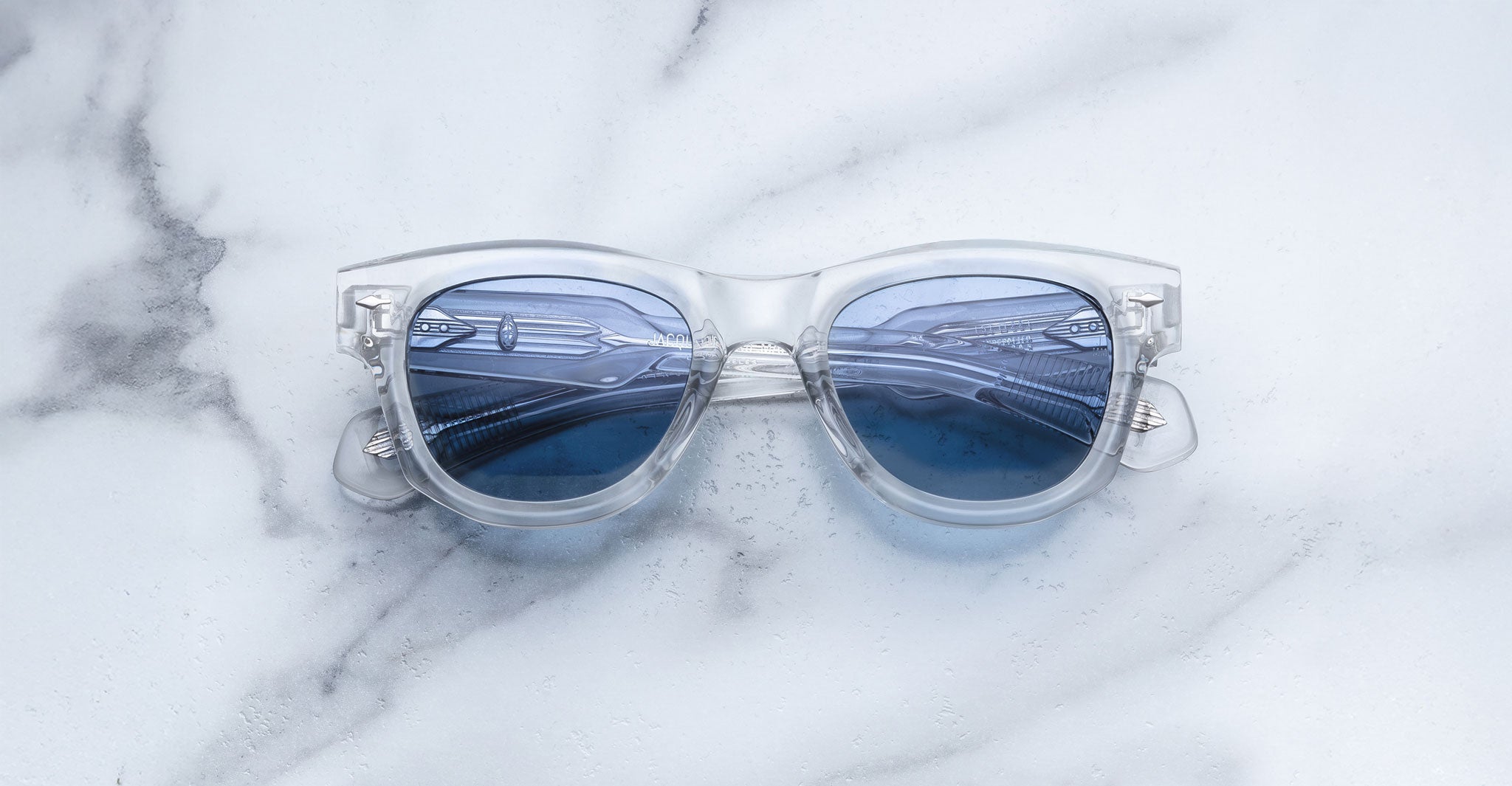 Jacques Marie Mage Kinshasa sunglasses with blue lenses and clear frames, front angle view.