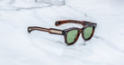 Jacques Marie Mage Kinshasa sunglasses with green polarized lenses and gold accents, shown from the front.