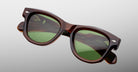 Jacques Marie Mage Kinshasa sunglasses with brown frame and green polarized lenses, front view.