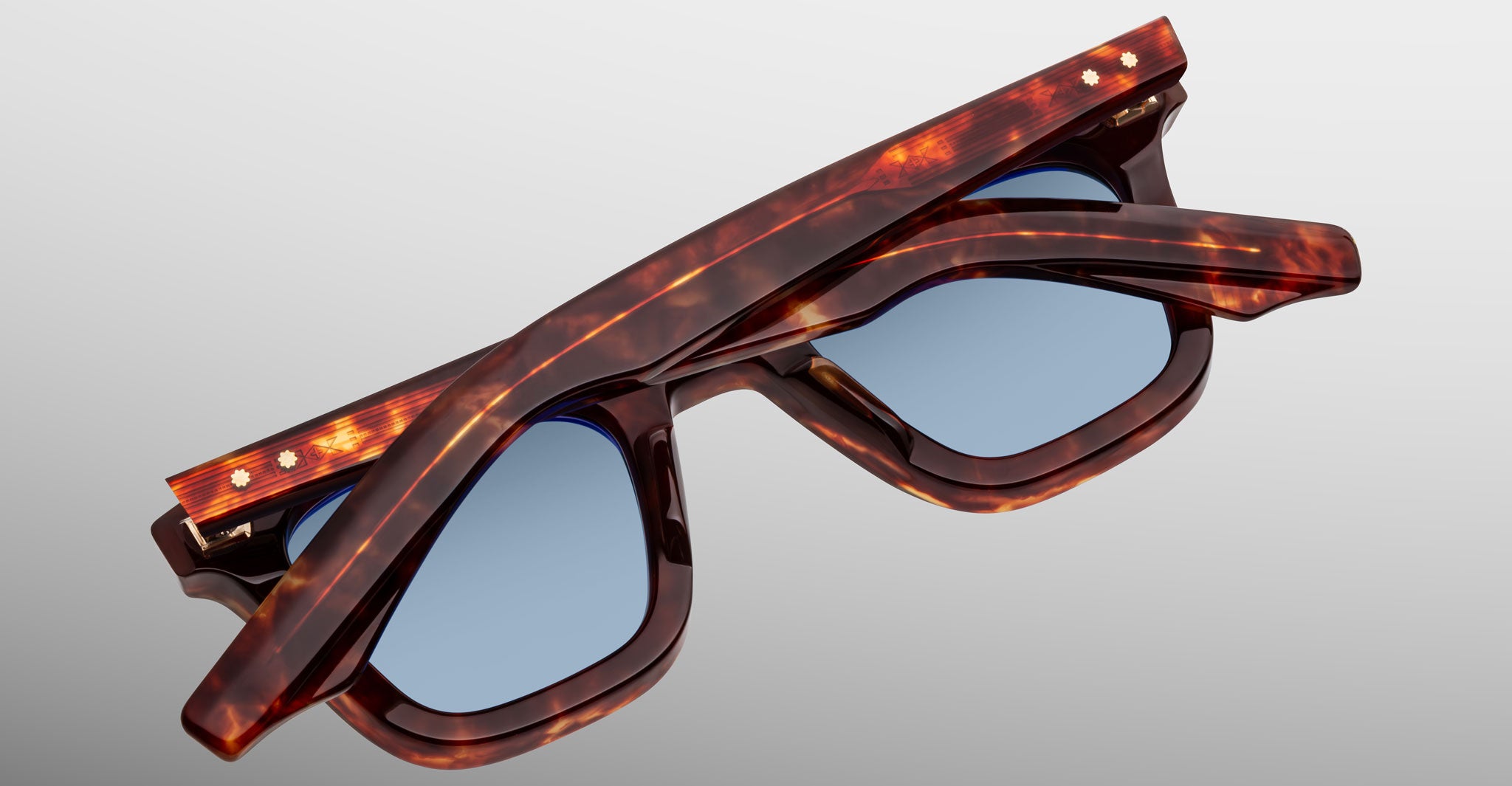 Jacques Marie Mage Leclair tortoiseshell sunglasses with blue lenses, shown folded from above on a plain, light background.