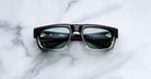 Jacques Marie Mage Louisville black sunglasses with green lenses, shown from above, featuring a bold frame design.