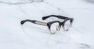Jacques Marie Mage Matsu eyeglasses, black and clear gradient thick frames, viewed from above.