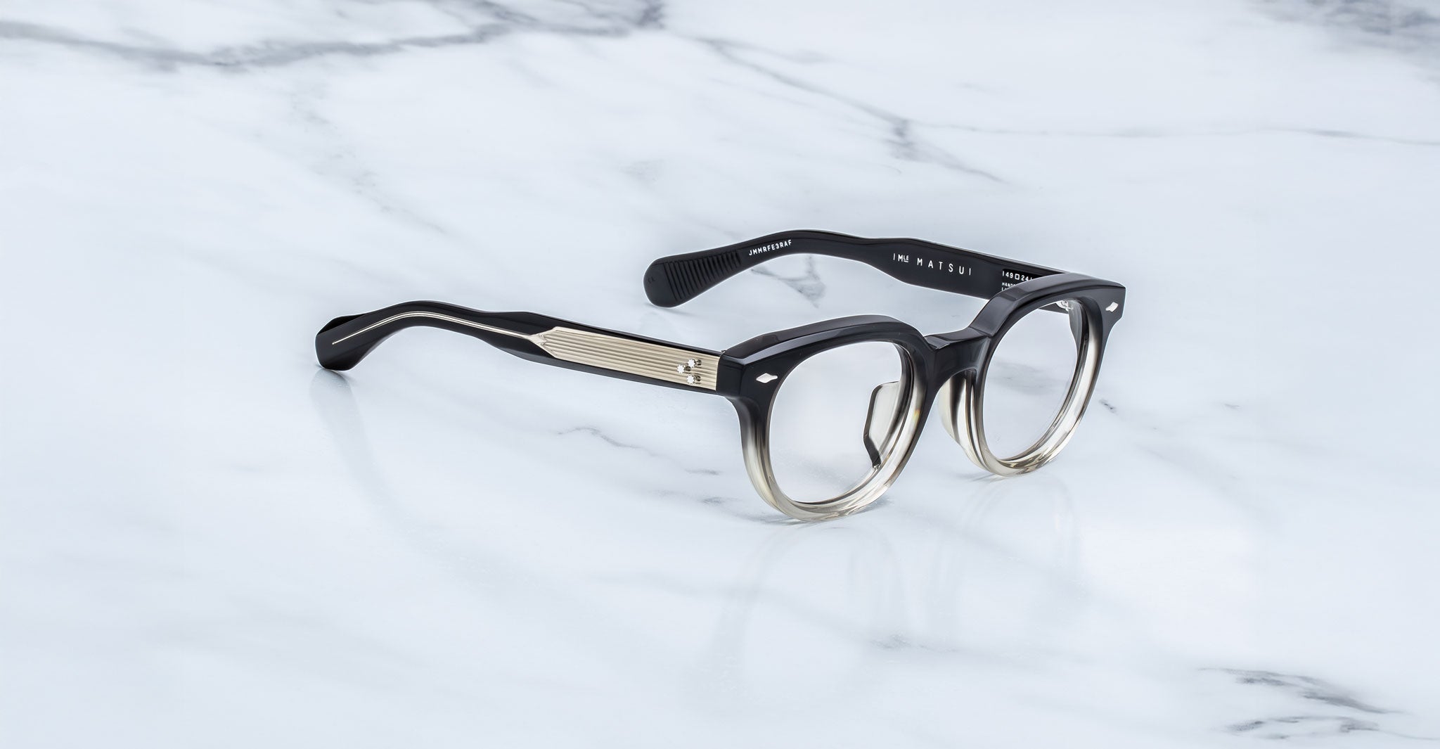 Jacques Marie Mage Matsu eyeglasses, black and clear gradient thick frames, viewed from above.