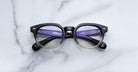 Jacques Marie Mage Matsu round eyeglasses in black and clear gradient, front view.
