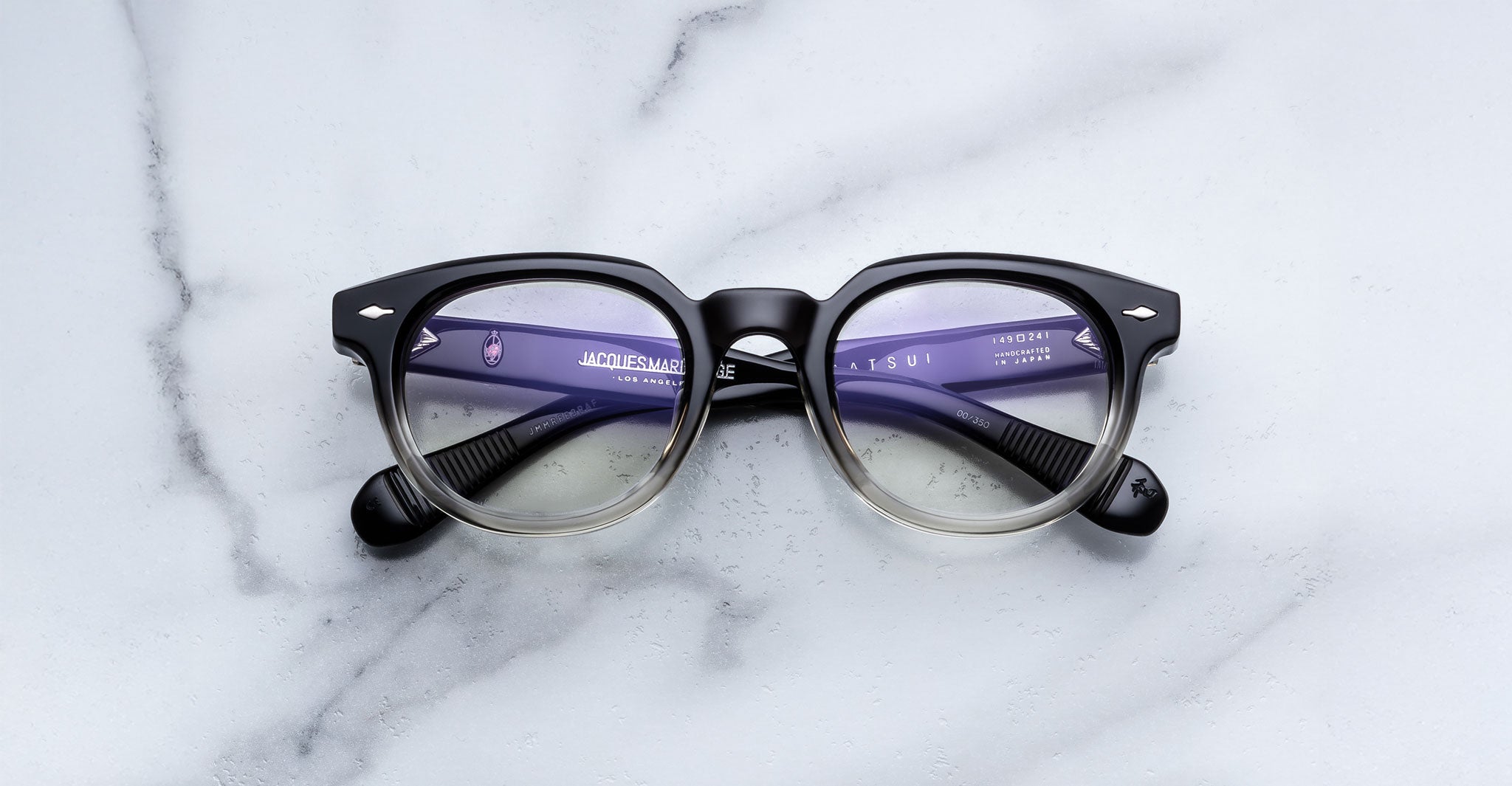 Jacques Marie Mage Matsu round eyeglasses in black and clear gradient, front view.