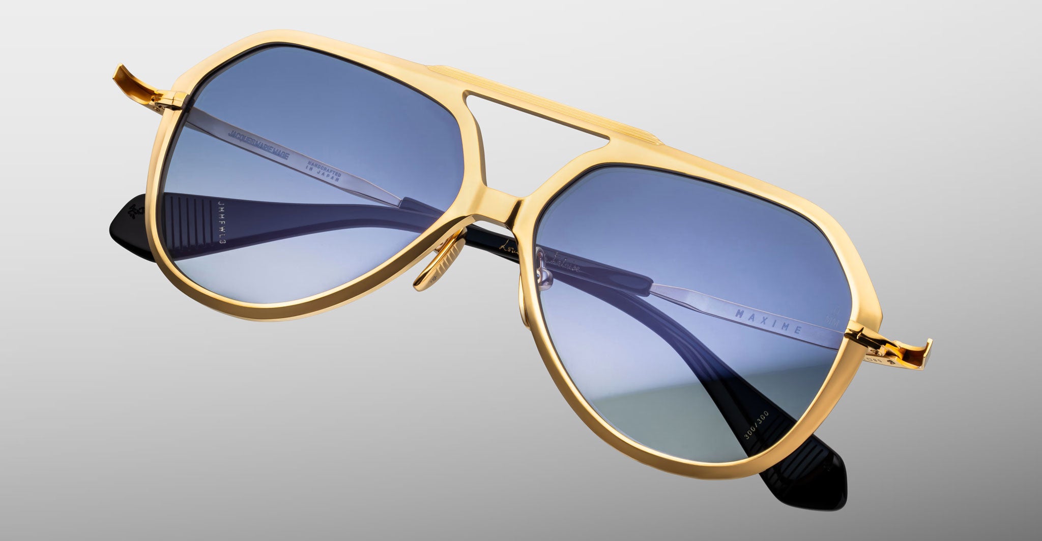 Jacques Marie Mage Maxime aviator sunglasses in gold with blue lenses and black polarized arms, shown from the front angle.