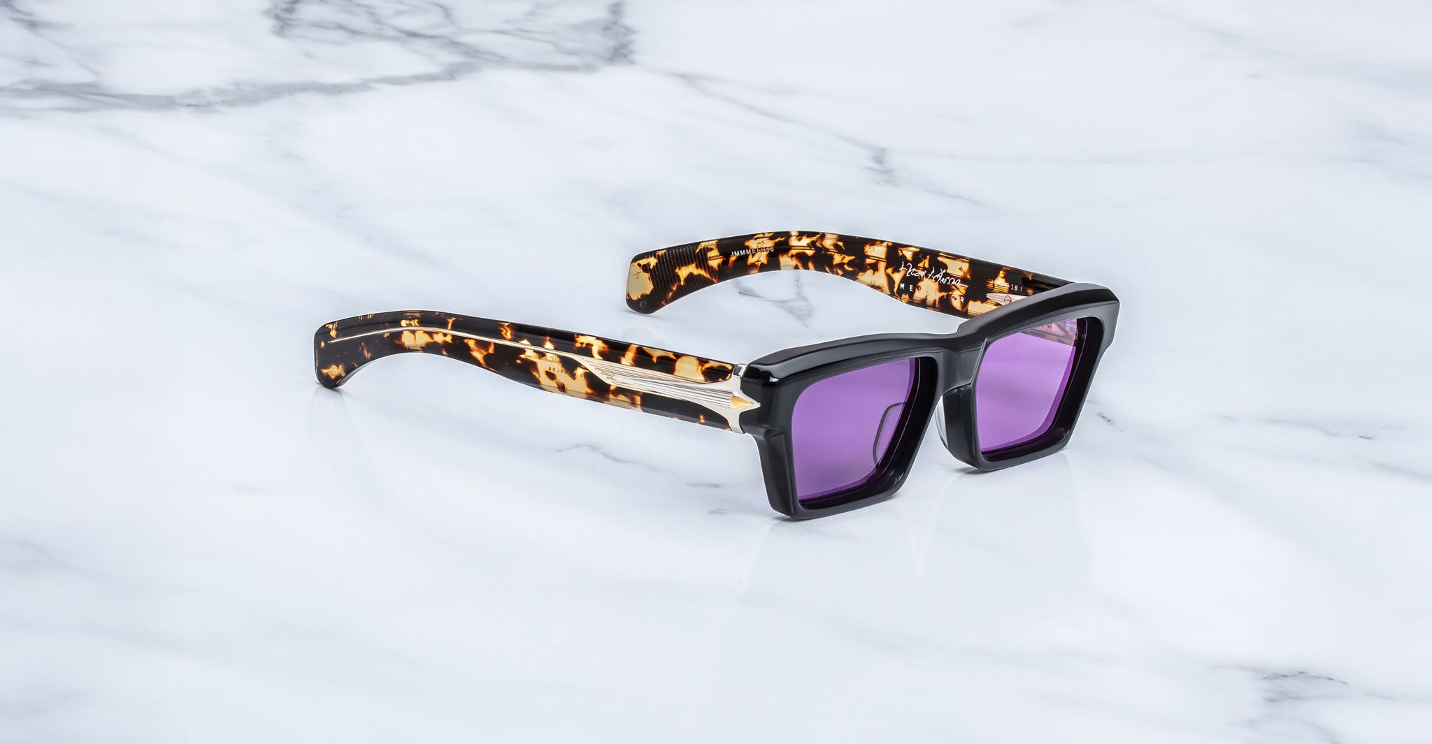 Jacques Marie Mage Melchior sunglasses with purple lenses, black frames, and tortoiseshell arms, front angle view.