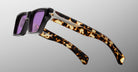 Jacques Marie Mage Melchior rectangular sunglasses with thick tortoiseshell frames and purple lenses, front view.