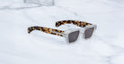 Jacques Marie Mage Melchior sunglasses with clear frames, UV-protected dark lenses, and tortoiseshell arms, front view.