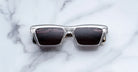 Jacques Marie Mage Melchior clear frame polarized sunglasses with dark lenses shown from above.
