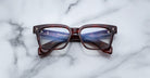 Jacques Marie Mage Molino 55 eyeglasses, front view, reflecting a digital screen on a white marble table.