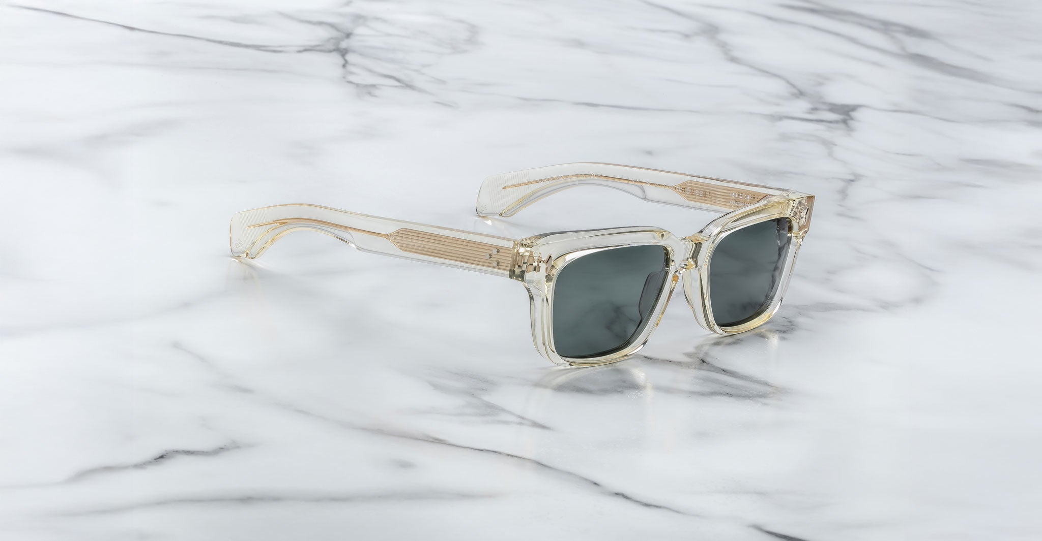 Jacques Marie Mage Molino 55 sunglasses feature clear frames and dark lenses, shown from above.