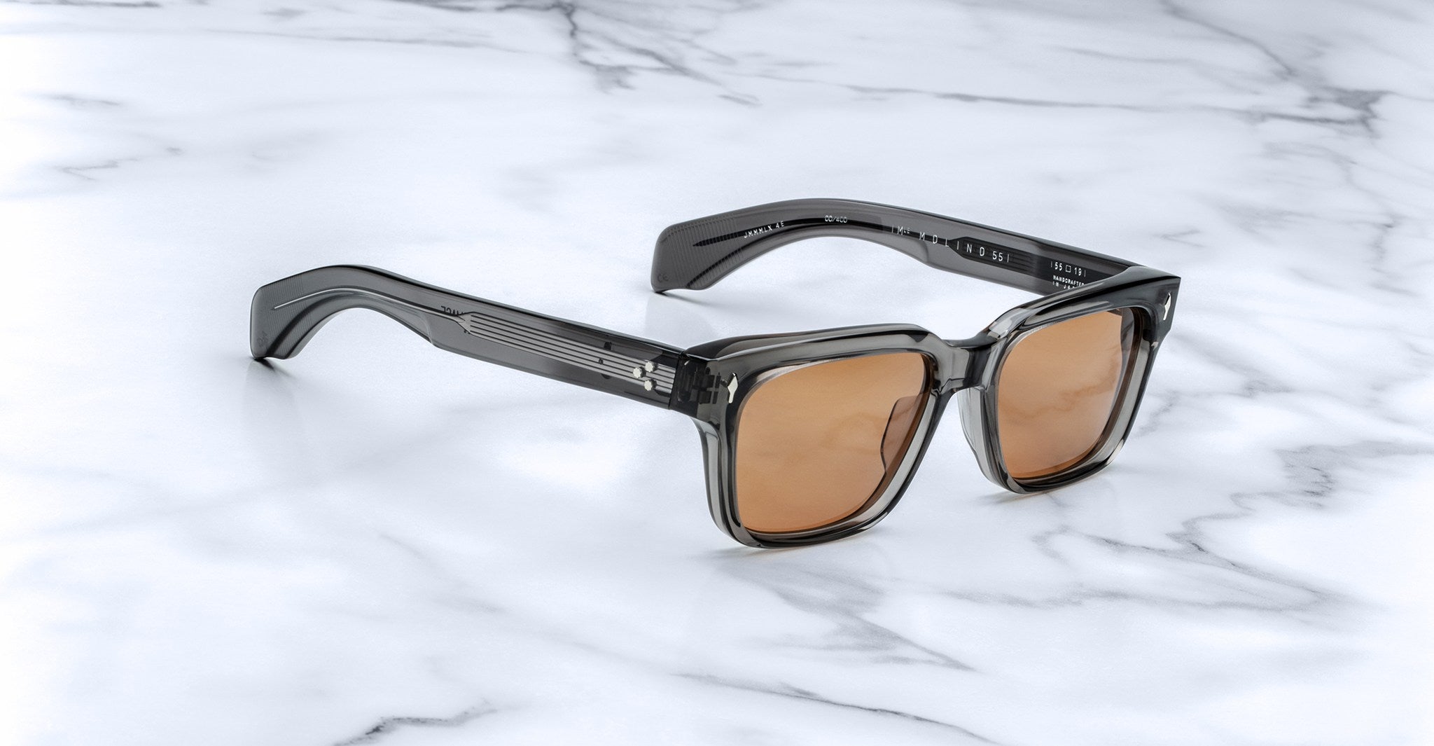 Jacques Marie Mage Molino 55 sunglasses, shown from the front, feature translucent gray square frames and UV-protection brown lenses.