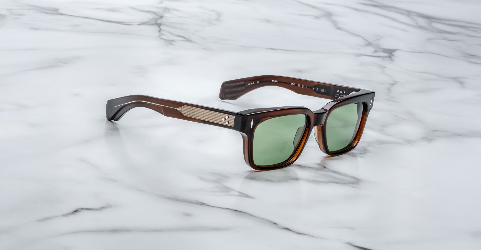 Jacques Marie Mage Molino 55 brown sunglasses with green lenses and metallic temple accents, shown from a top-down angle.