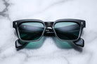 Jacques Marie Mage Walker black rectangular sunglasses with green lenses, top view.