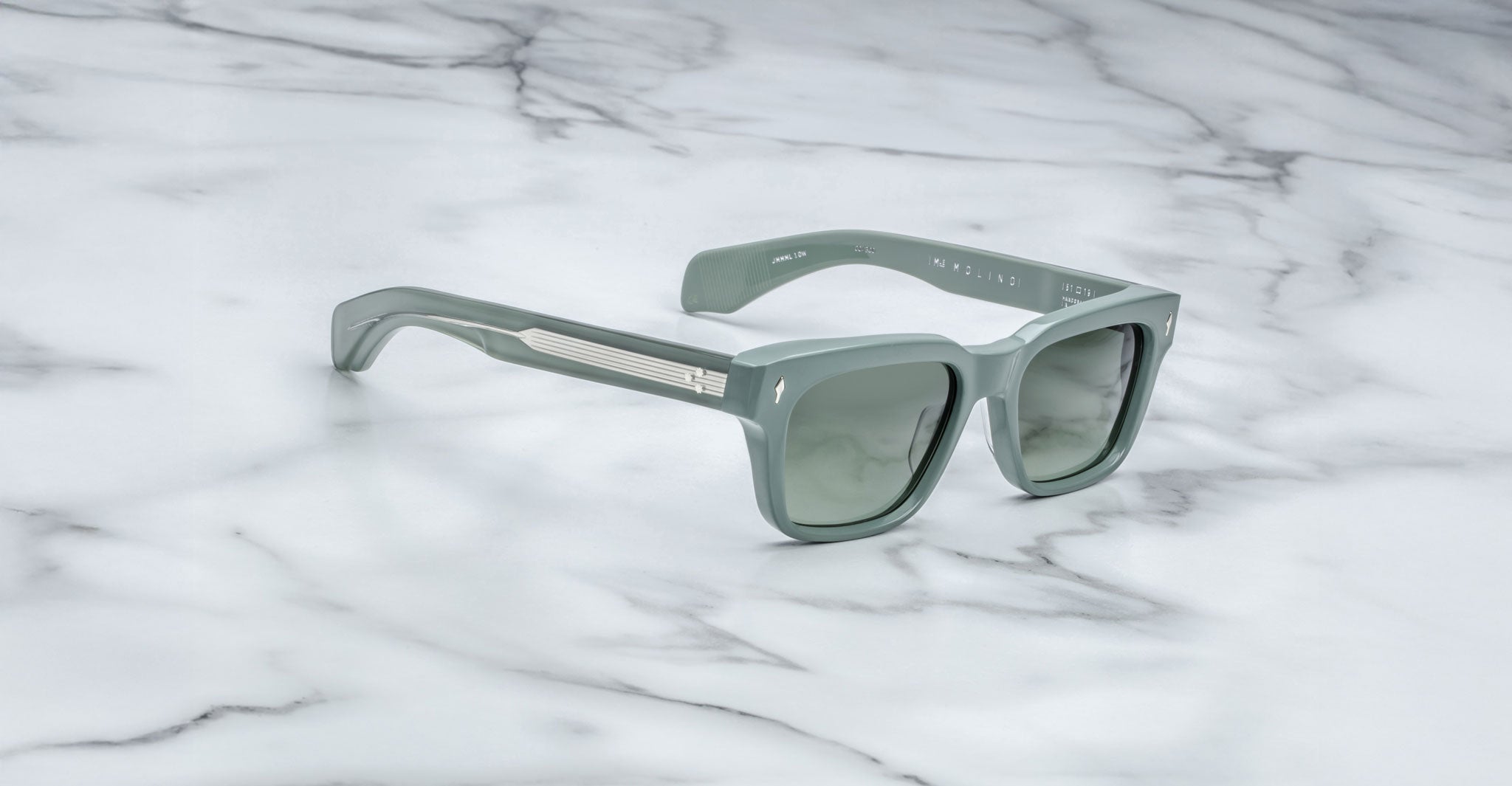 Jacques Marie Mage Molino gray rectangular sunglasses with thick frames and metal accents, shown from above.