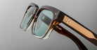 Close-up of Jacques Marie Mage Molino sunglasses with green-tinted lenses and metallic accents, viewed from the front.