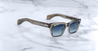 Jacques Marie Mage Molino sunglasses with translucent brown frames and blue gradient lenses, shown from above.