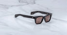 Jacques Marie Mage Molino black rectangular sunglasses with UV-protective lenses, shown from above.