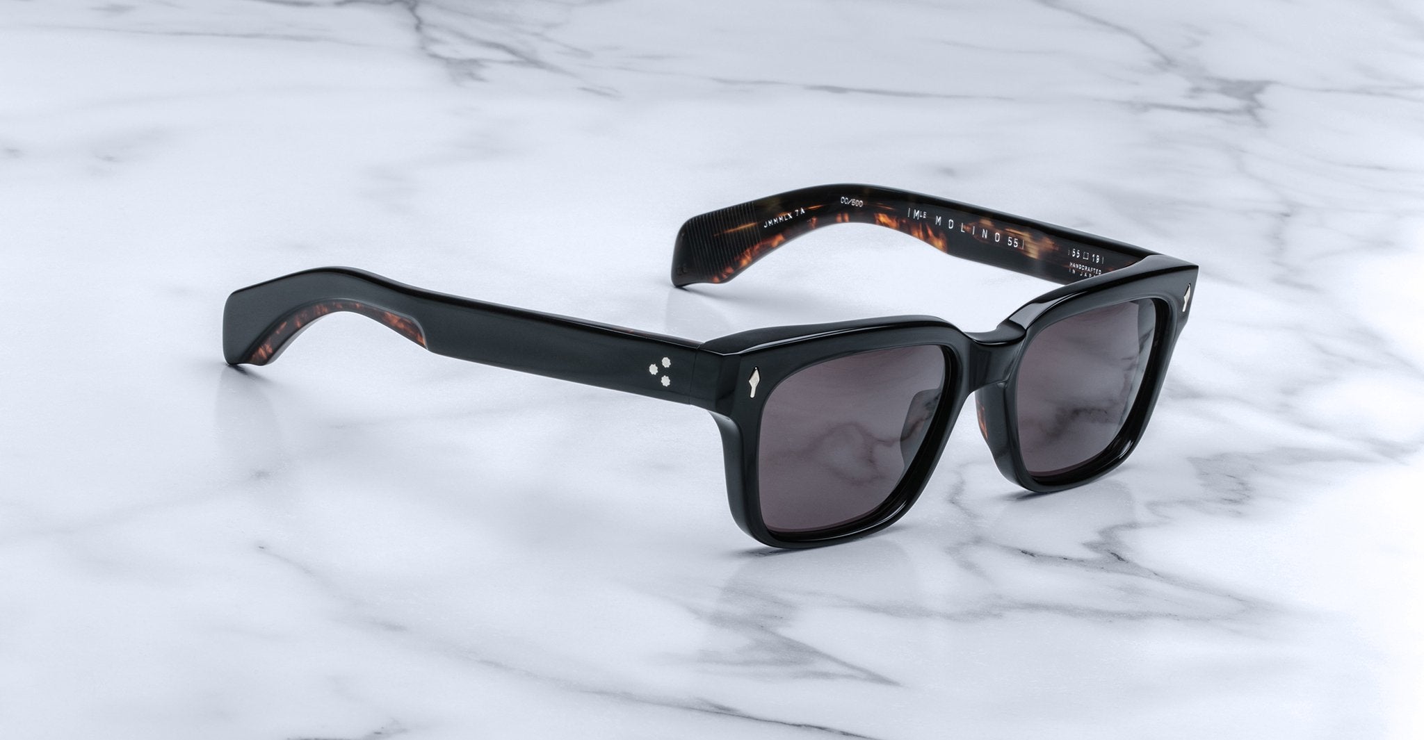 Jacques Marie Mage Molino 55 sunglasses with black square frames and dark lenses, viewed from above.