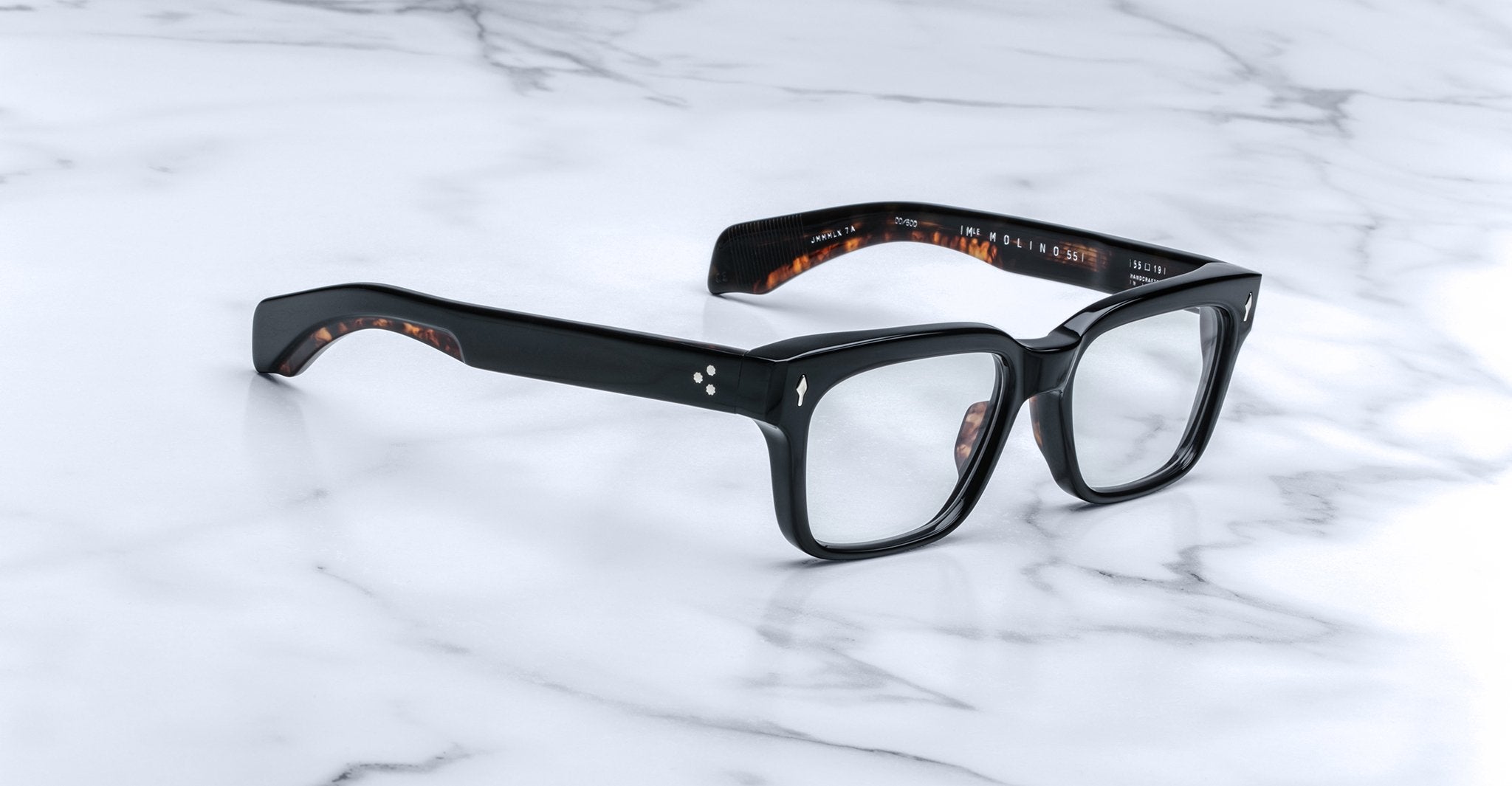 Jacques Marie Mage Molino 55 eyeglasses, black rectangular frame with tortoiseshell arms, shown from above.