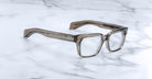 Jacques Marie Mage Molino 55 thick-rimmed rectangular eyeglasses, front view, displayed on a marble surface.