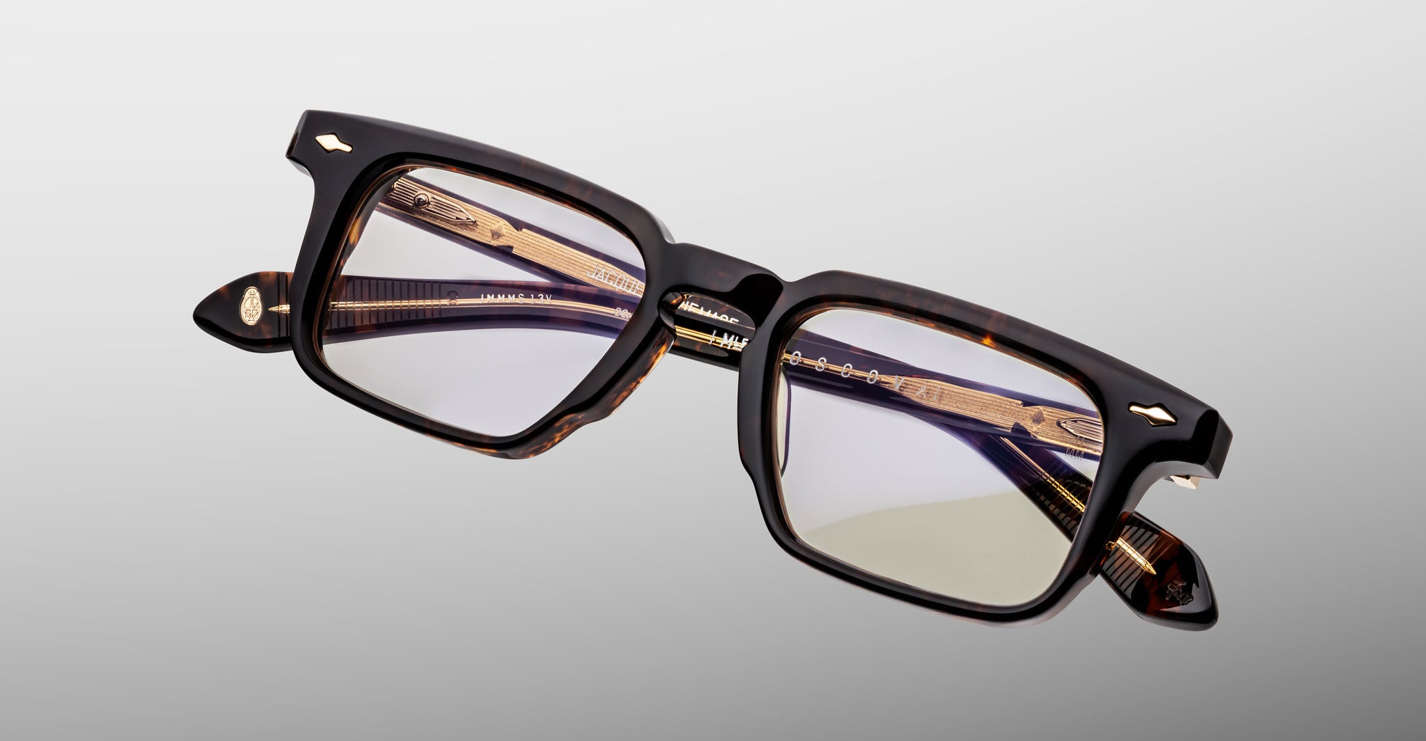 Jacques Marie Mage Moscova in Beau acetate optical frame, angled view highlighting rectangular lenses, rich tortoiseshell acetate front, signature arrowhead pins, and exposed core wire temples with warm tonal detailing