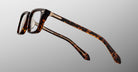 Jacques Marie Mage Moscova in Beau acetate optical frame, side profile highlighting sculpted tortoiseshell acetate, gold hardware at the hinge, signature arrowhead pin, and tapered temples with exposed core wire and warm tonal interior detailing