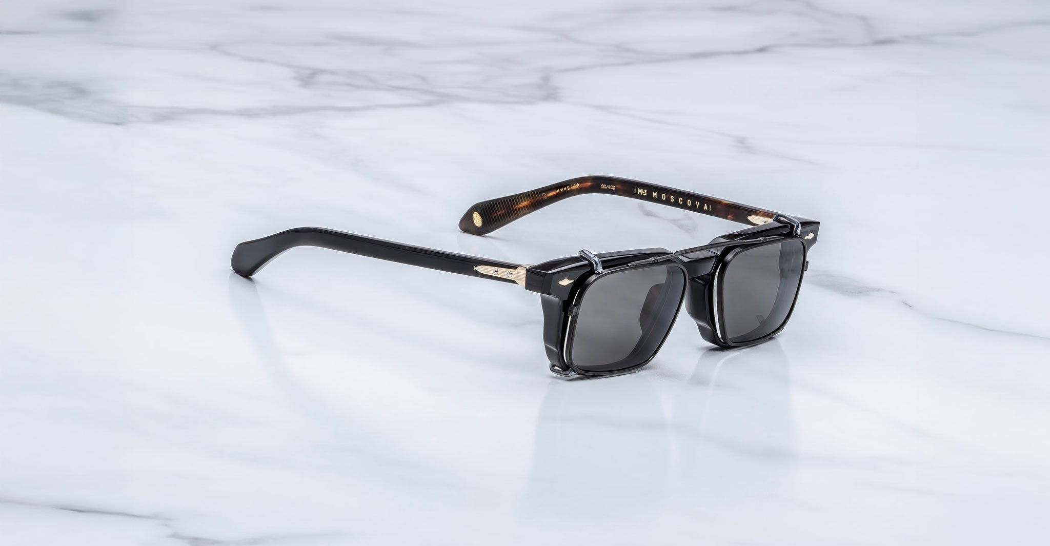Jacques Marie Mage Moscova in Noir 15 acetate optical frame with Black clip-on, angled view featuring rectangular dark-tinted lenses, polished black acetate, signature arrowhead pins, and slim black clip-on attachment with exposed core wire temples