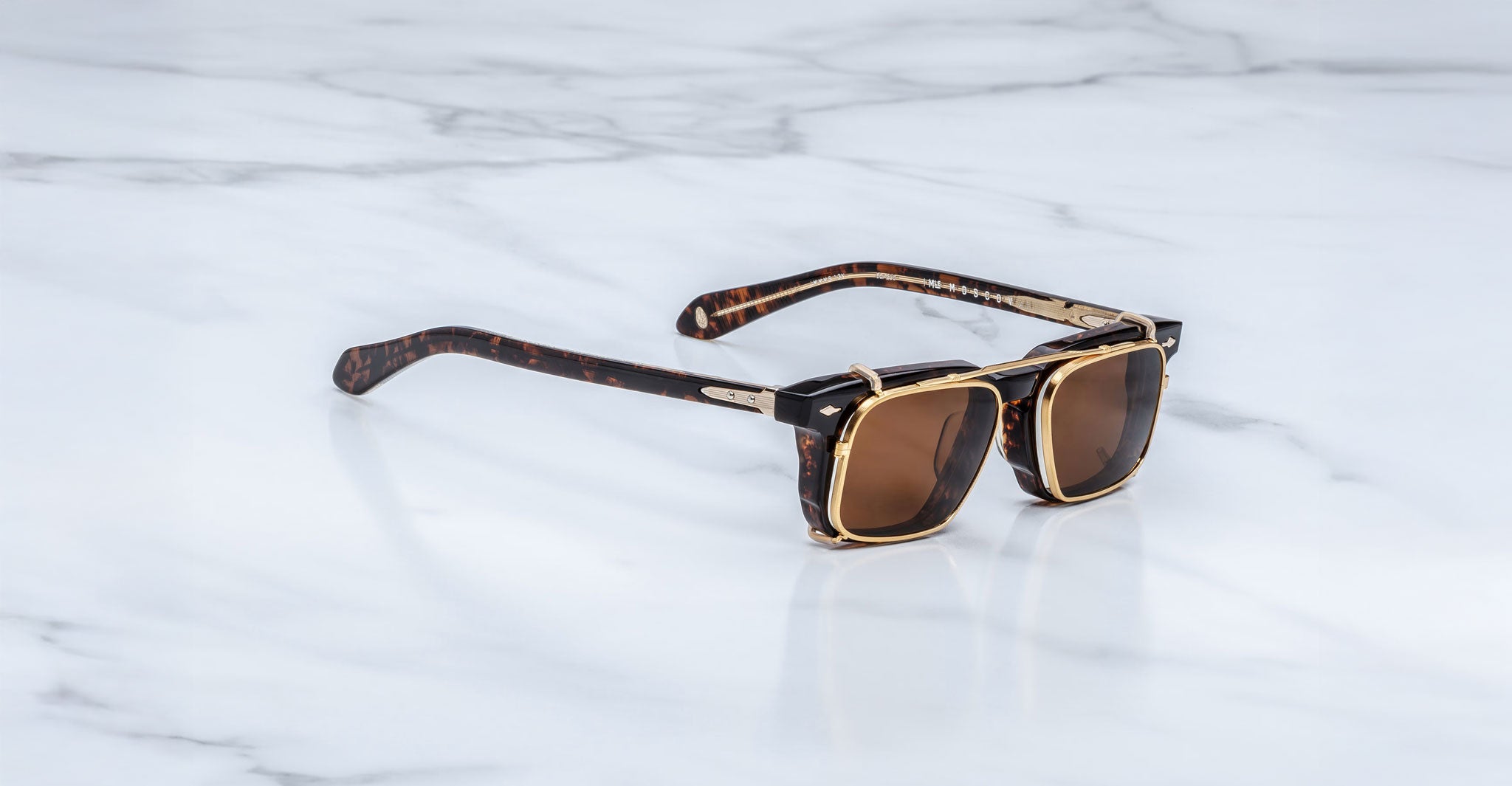 Jacques Marie Mage Moscova in Beau acetate optical frame with Gold clip-on, angled view featuring rectangular brown-tinted lenses, rich tortoiseshell acetate, signature arrowhead pins, and polished gold clip-on attachment with exposed core wire temples
