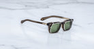 Jacques Marie Mage Moscova in London acetate optical frame with Silver clip-on, angled view featuring rectangular green-tinted lenses, translucent brown acetate, signature arrowhead pins, and slim silver clip-on attachment with exposed core wire temples