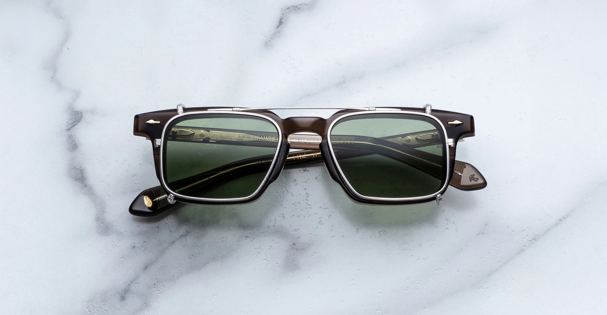 Jacques Marie Mage Moscova in London acetate optical frame with Silver clip-on, front-facing view featuring rectangular green-tinted lenses, translucent brown acetate, signature arrowhead pins, and slim silver clip-on attachment across the bridge