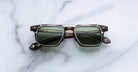Jacques Marie Mage Moscova in London acetate optical frame with Silver clip-on, front-facing view featuring rectangular green-tinted lenses, translucent brown acetate, signature arrowhead pins, and slim silver clip-on attachment across the bridge