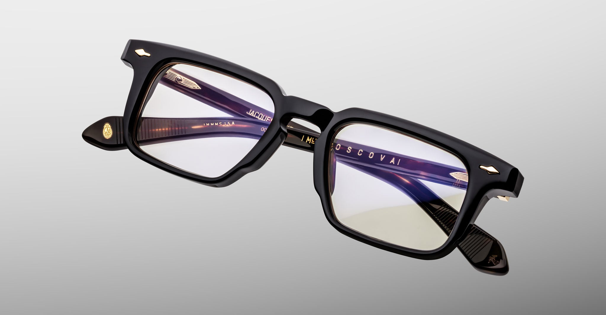 Jacques Marie Mage Moscova in Noir 15 acetate optical frame, angled view highlighting rectangular lenses, bold sculpted black front, signature arrowhead pins, and exposed core wire temples with warm tortoiseshell interior detailing