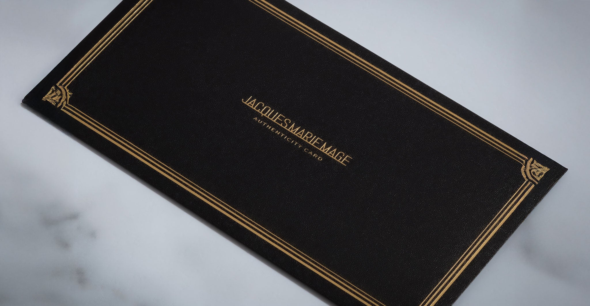 Jacques Marie Mage Kinshasa eyeglasses on a black card with gold border, centered gold text, front view.
