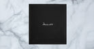 Jacques Marie Mage Kinshasa eyeglasses case in black with white signature, top view.