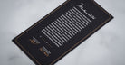 Jacques Marie Mage Kinshasa eyeglasses card, black with gold borders, shows two signatures and bold script at the top.