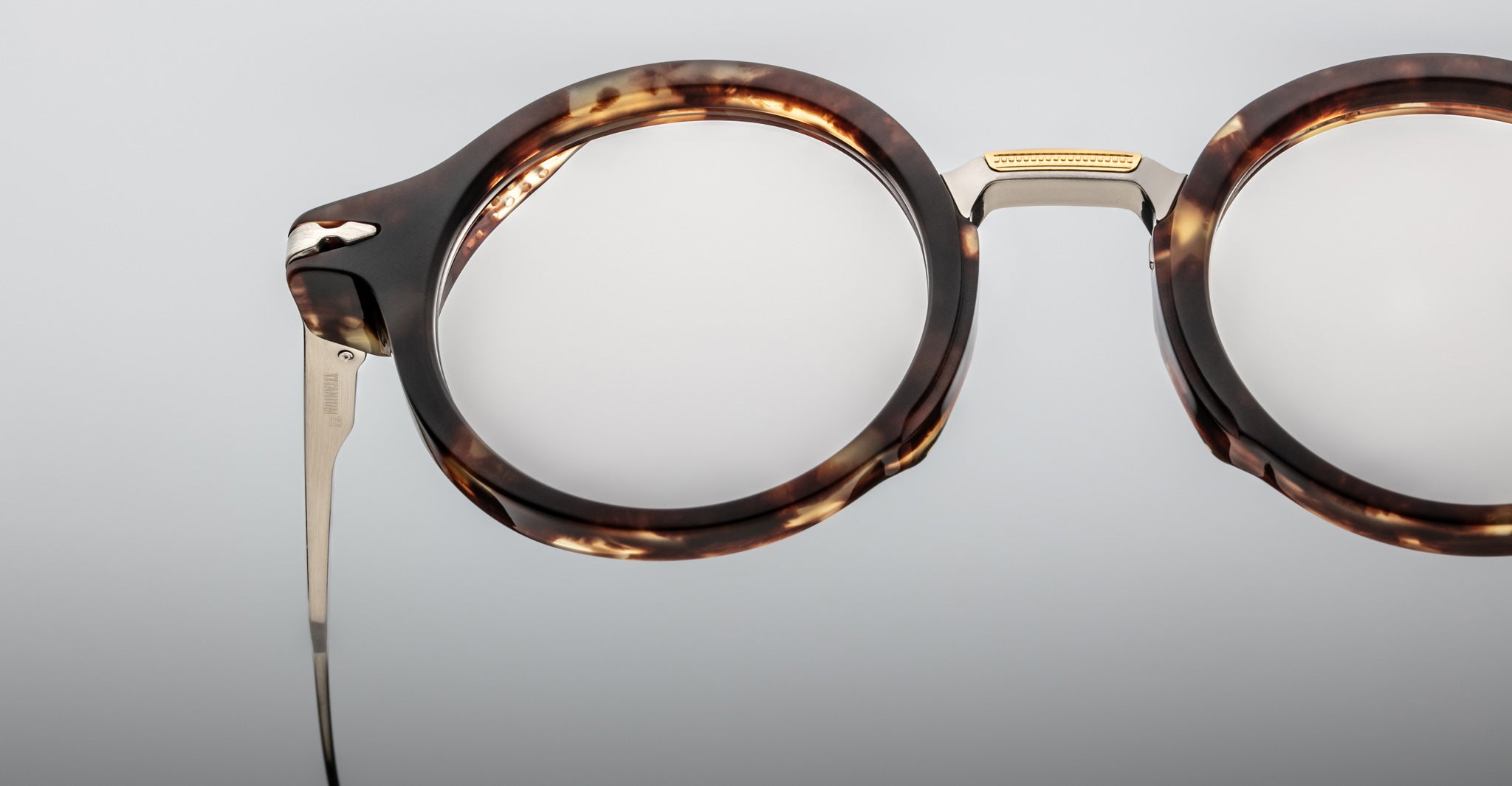 Close-up of Jacques Marie Mage Norman eyeglasses, round tortoiseshell frames with metal temples, front angle.