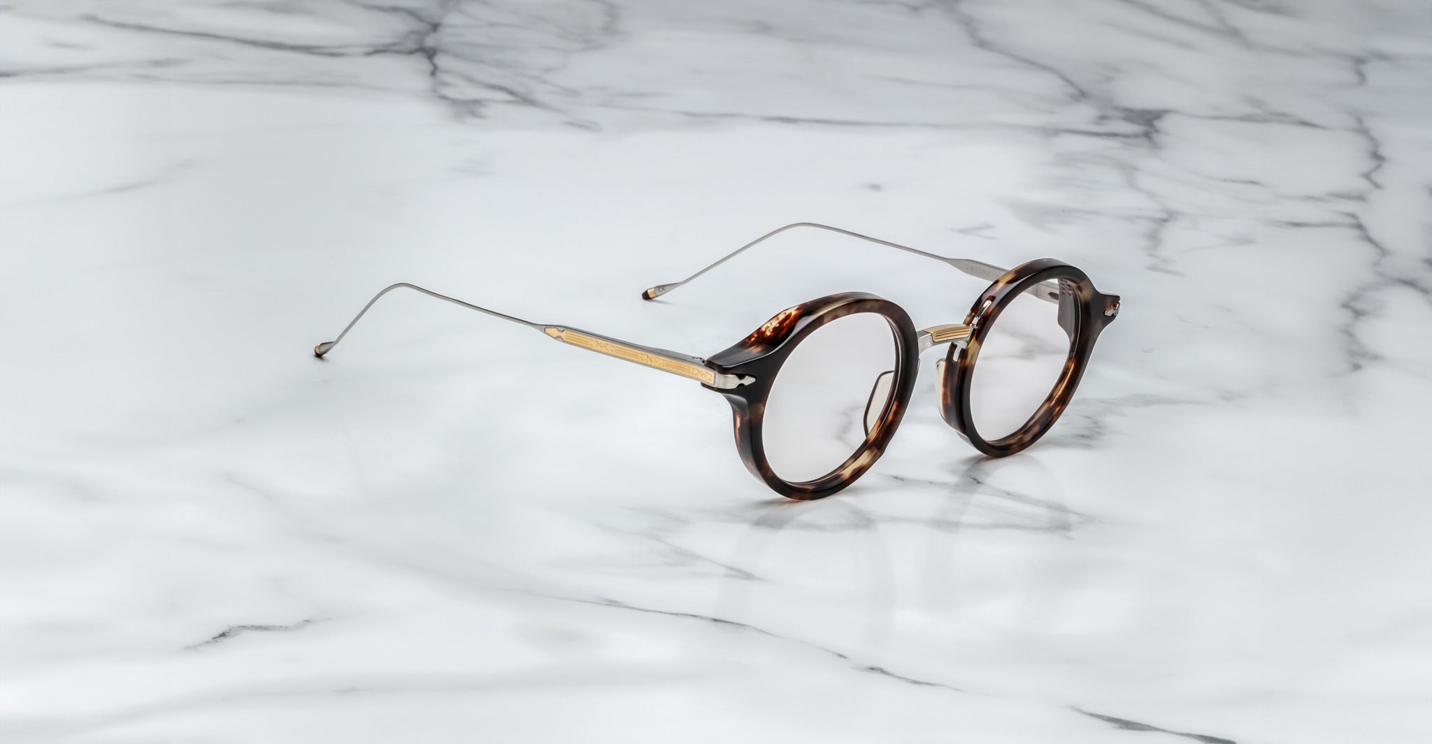 Jacques Marie Mage Norman round tortoiseshell eyeglasses with thin gold arms, shown from above.