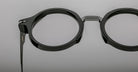Close-up of Jacques Marie Mage Norman black round eyeglasses with clear lenses, showing the front and side profile.