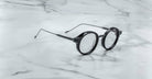 Jacques Marie Mage Norman eyeglasses, open and viewed from above, displayed on a flat white surface.