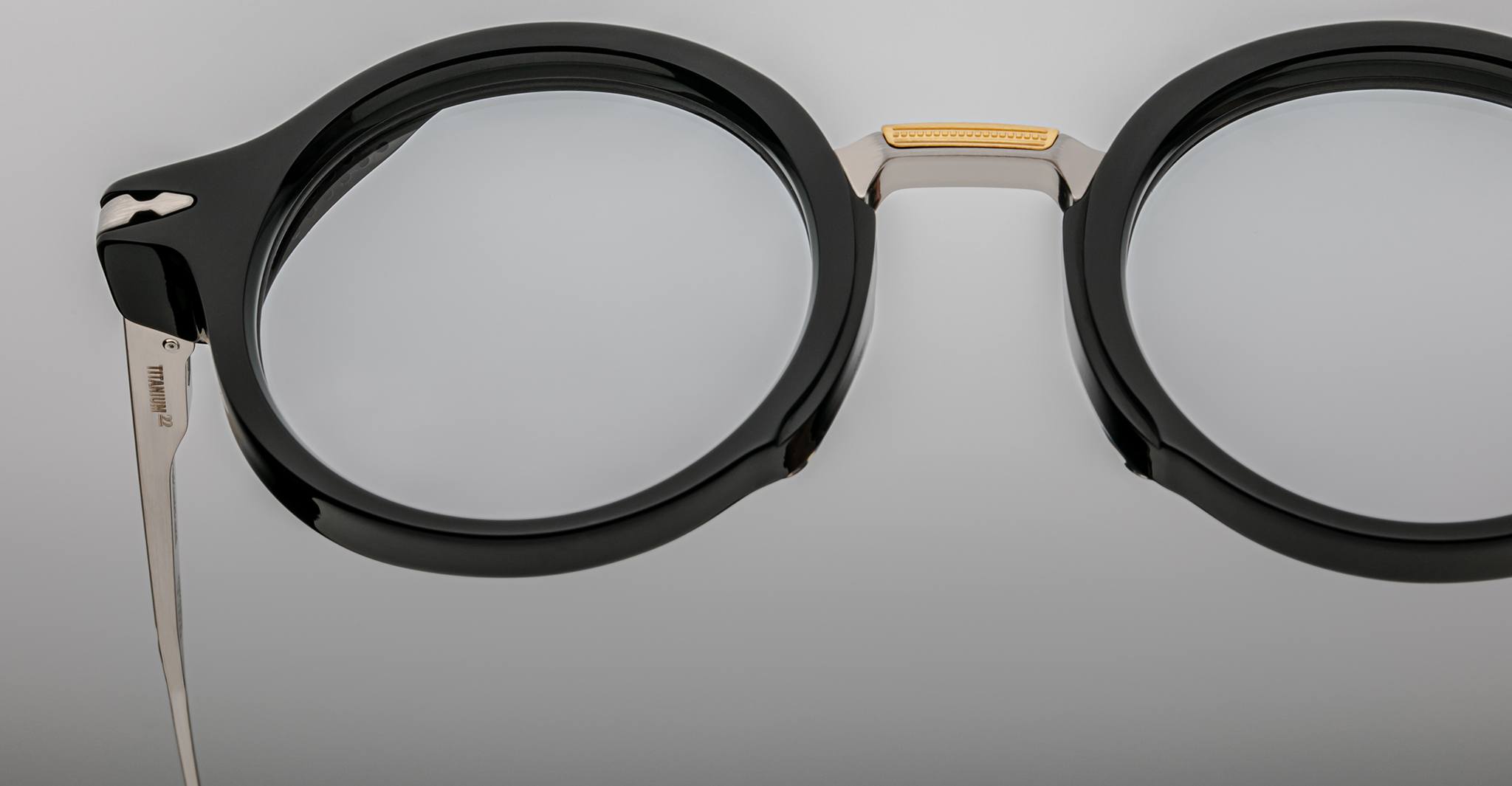 Close-up of Jacques Marie Mage Norman black round eyeglasses, featuring metal bridge and temples, viewed from the front.