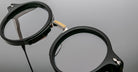 Close-up of Jacques Marie Mage Norman round black eyeglasses with gold bridge; product shown from the front.