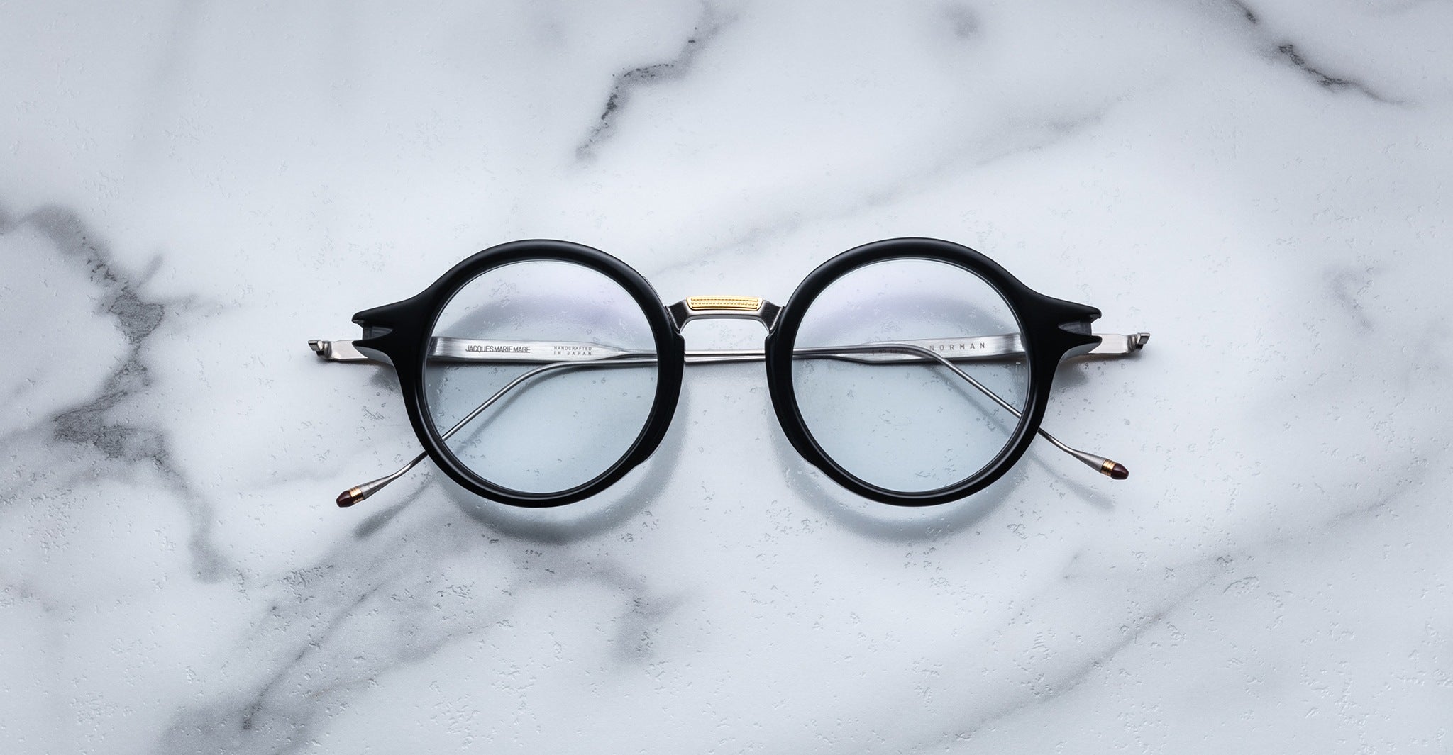Jacques Marie Mage Norman black-rimmed eyeglasses with clear lenses, top-down view.