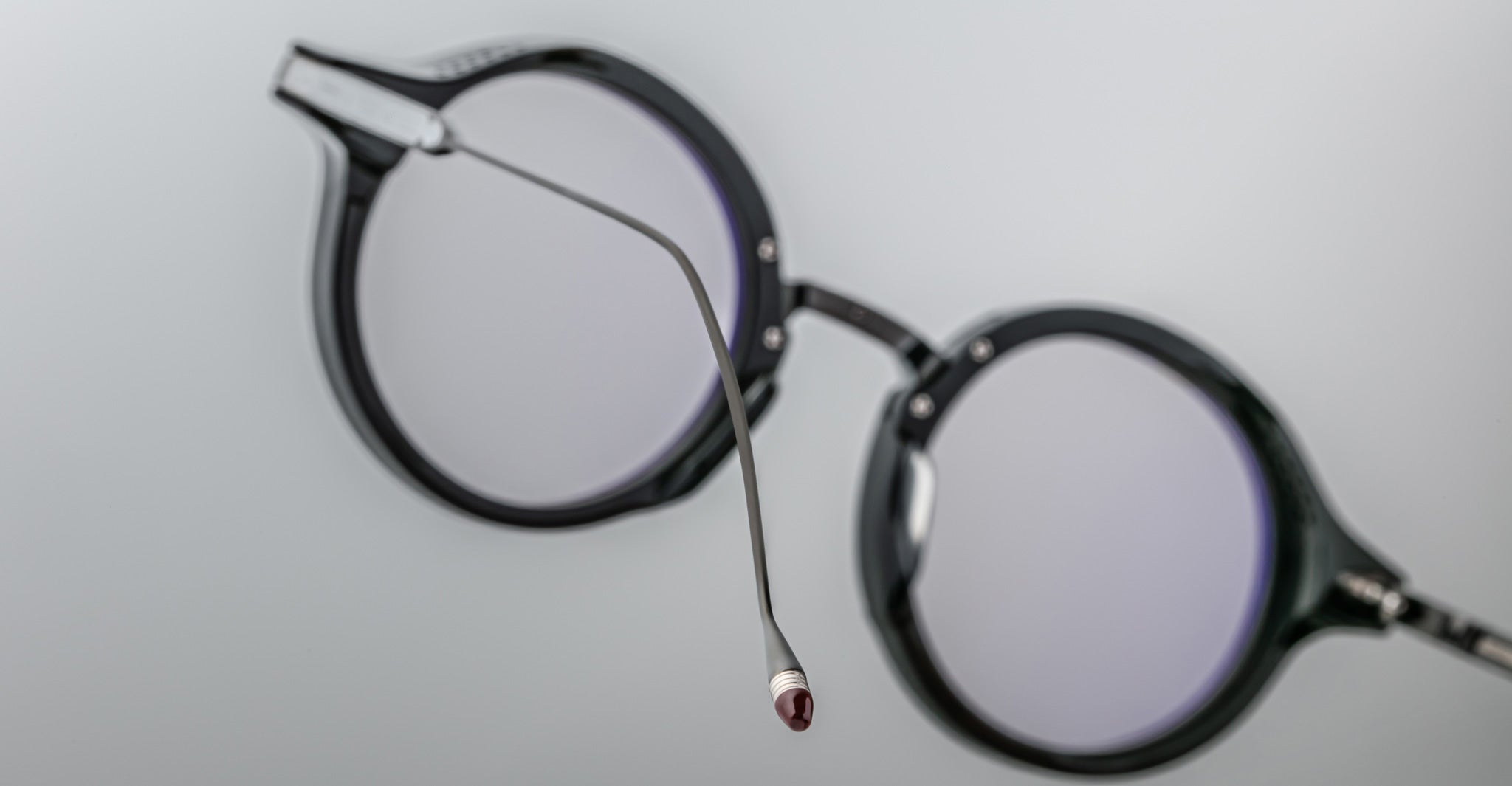 Close-up of Jacques Marie Mage Norman black round eyeglasses, side view showing one extended arm.