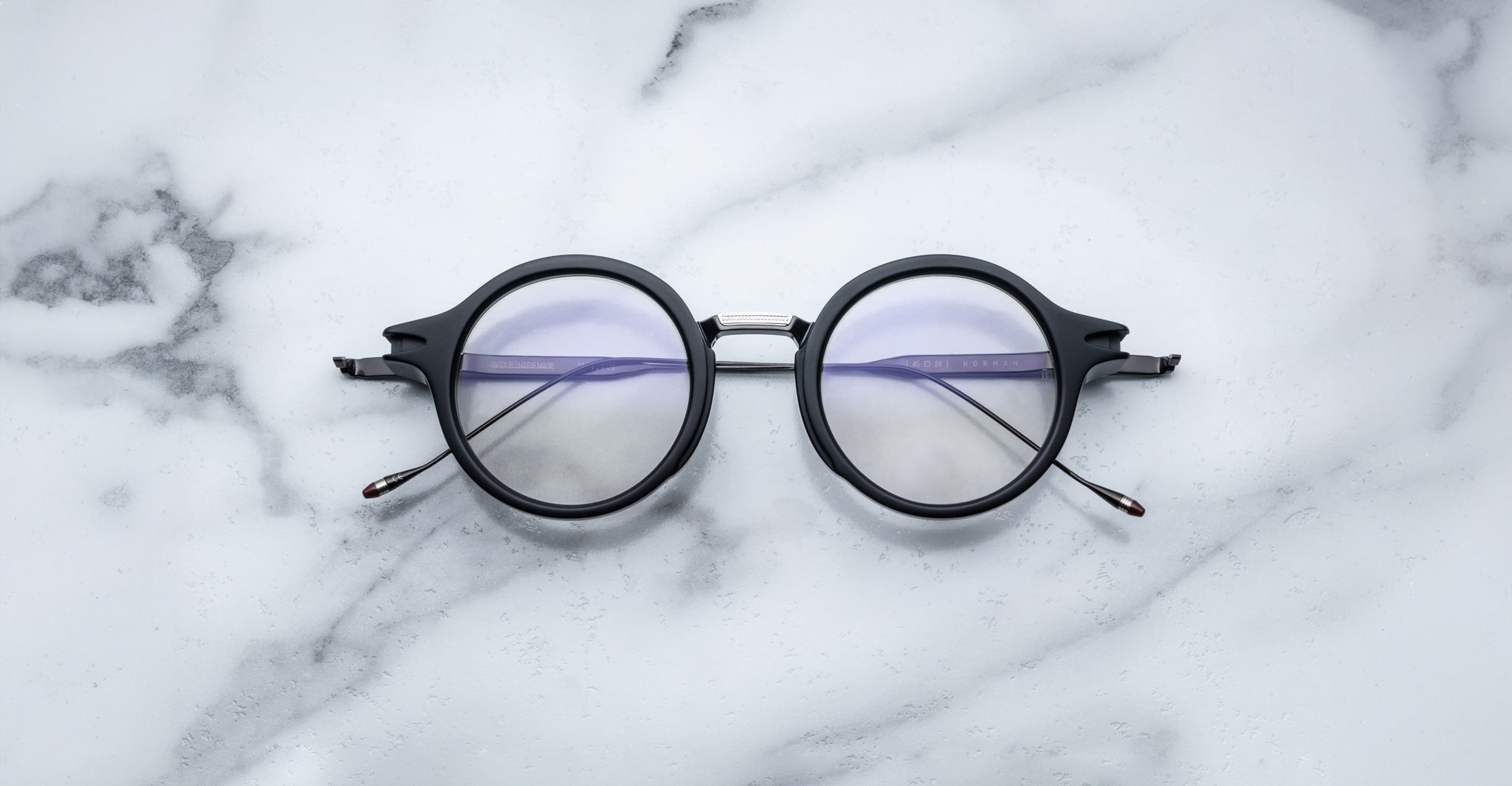 Jacques Marie Mage Norman black eyeglasses with clear lenses, shown from above.