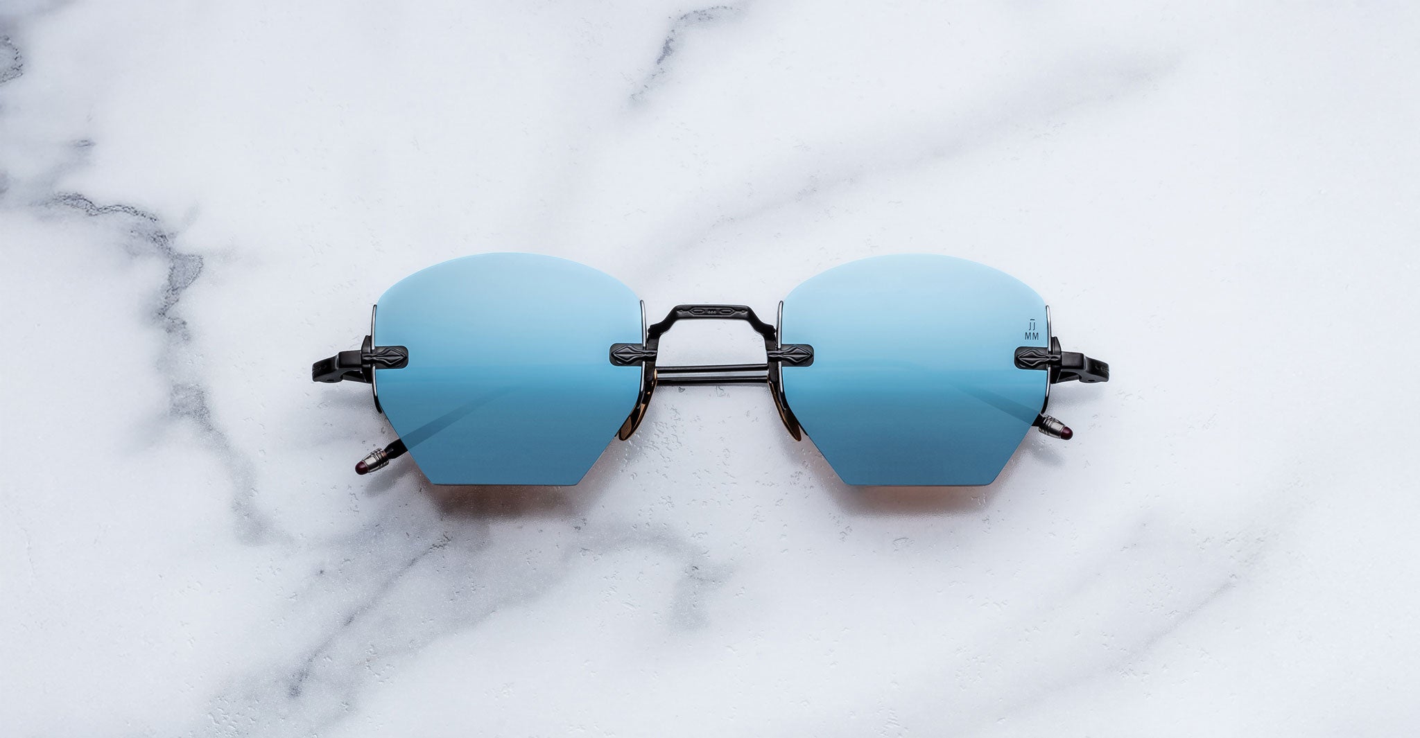 Jacques Marie Mage Oatman in Lagoon sunglasses with blue lenses and black frames, UV protection, shown from above.