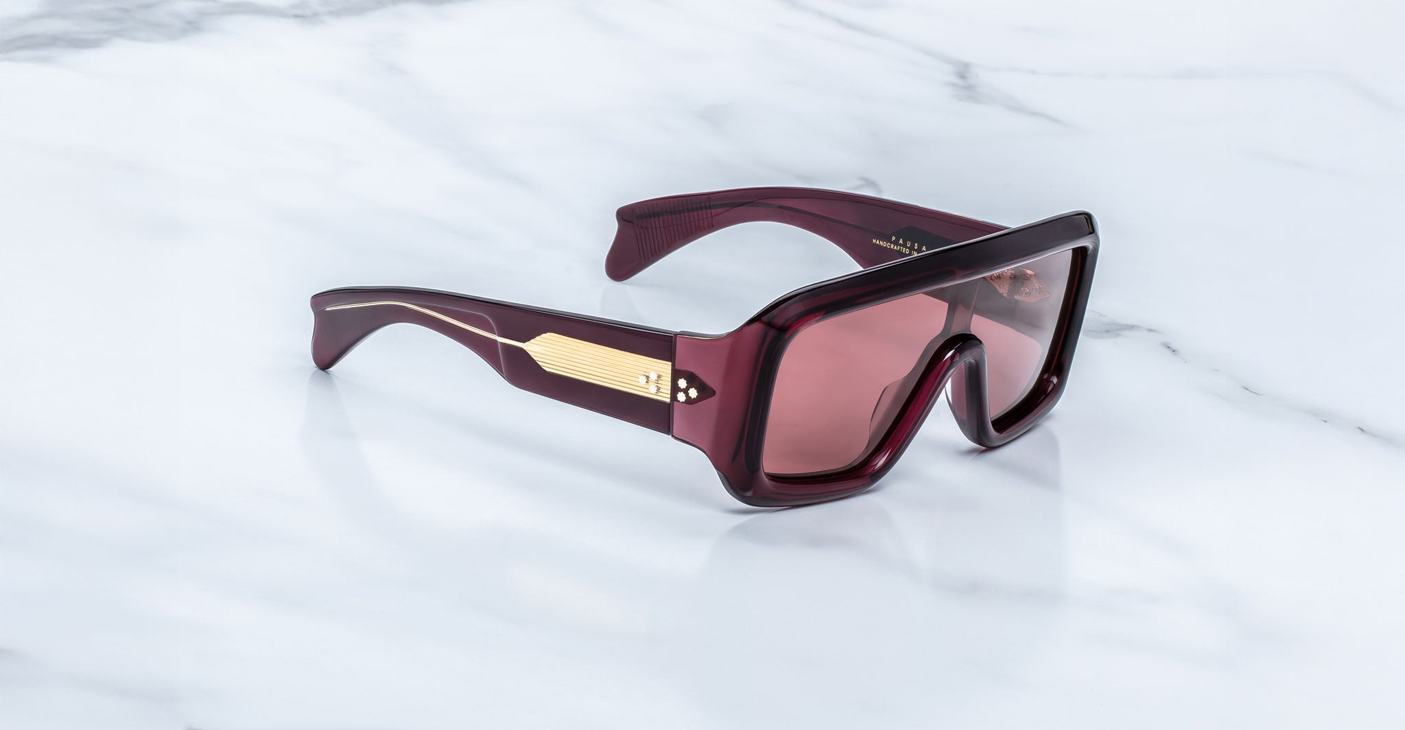 Jacques Marie Mage Pausa sunglasses, featuring gold-accented arms, shown from above.
