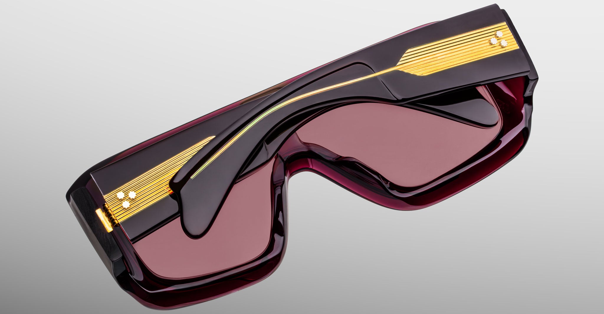Jacques Marie Mage Pausa sunglasses with dark red lenses and black-gold frames, shown from the front.